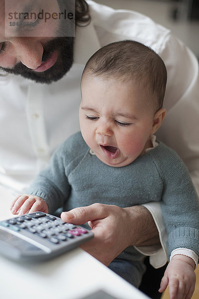 Cute Baby Mädchen gähnen mit Vater mit Rechner zu Hause
