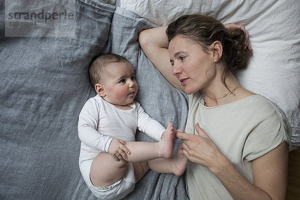 Direkt über der Aufnahme der Mutter  die das Mädchen im Bett ansieht.