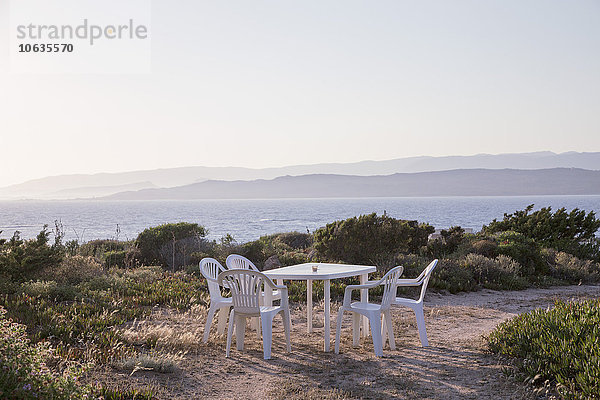 Stühle und Tisch am Strand gegen den klaren Himmel