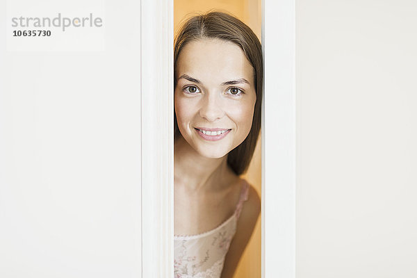 Porträt einer schönen Frau  die lächelt  während sie durch die Türen schaut.