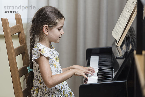 Seitenansicht des Mädchens beim Klavierspielen zu Hause