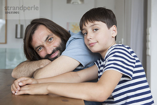 Porträt von Vater und Sohn am Tisch sitzend im Haus