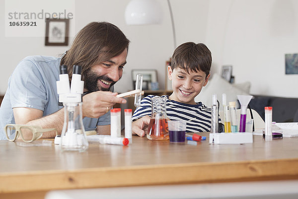 Vater und Sohn arbeiten zu Hause an einem schulwissenschaftlichen Projekt