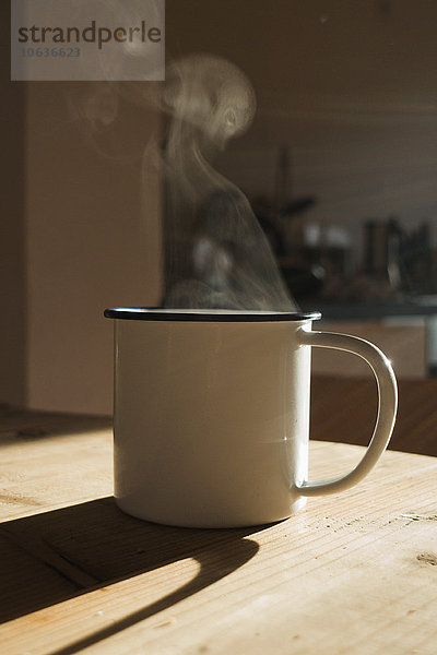 Ein dampfendes Heißgetränk im Becher mit Sonnenlicht  Nahaufnahme