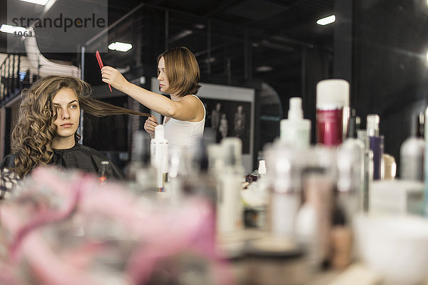 Friseur beim Kämmen der Haare von Models