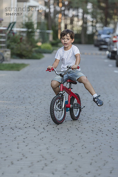 Junge fährt Fahrrad auf der Straße