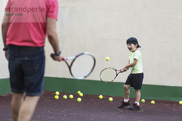 Vater und Sohn spielen Tennis auf dem Spielfeld