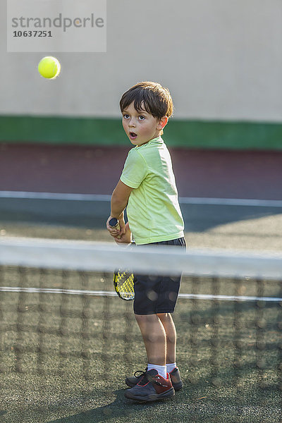 Junge beim Tennisspielen auf dem Platz