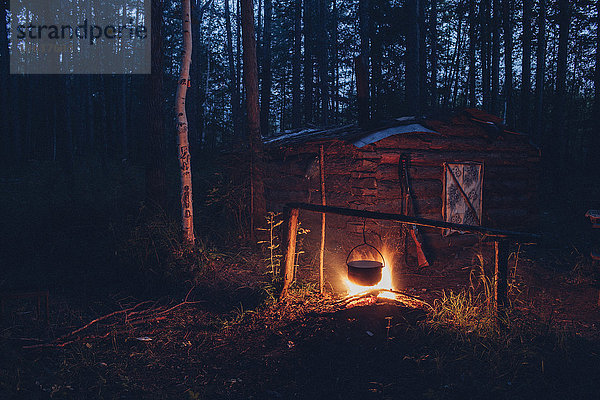 Container hängend über dem Lagerfeuer im Wald