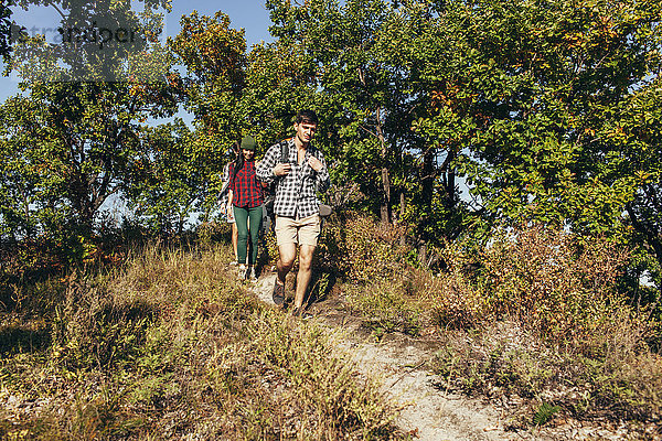 Männliche und weibliche Freunde beim Wandern im Wald