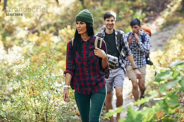 Junge Frau beim Wandern mit Freunden im Wald