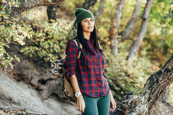 Porträt einer selbstbewussten Frau beim Wandern im Wald