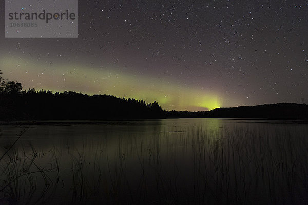 Idyllischer Blick auf Aurora Borealis am See bei Nacht