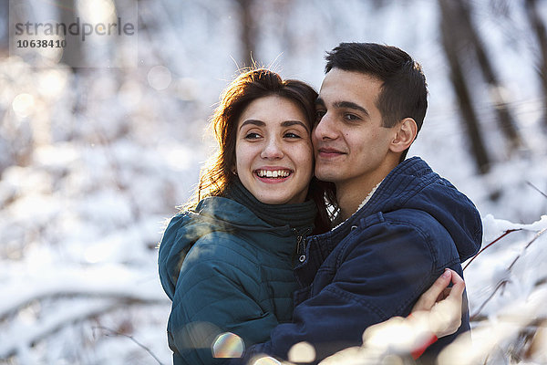 Liebevolles junges Paar  das sich im Winter umarmt.