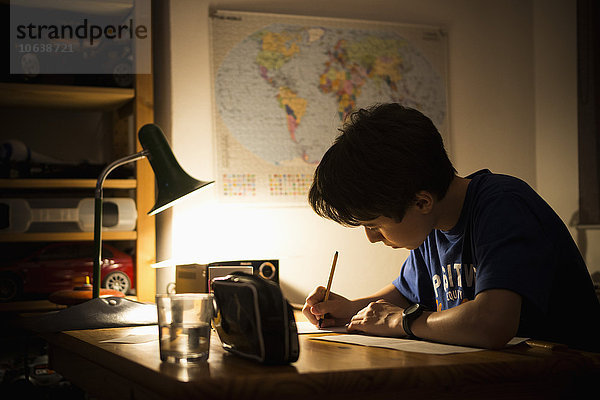 Teenager-Junge beim Lernen am Tisch im Haus