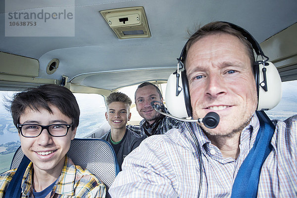 Porträt von Männern und Jugendlichen im Privatflugzeug