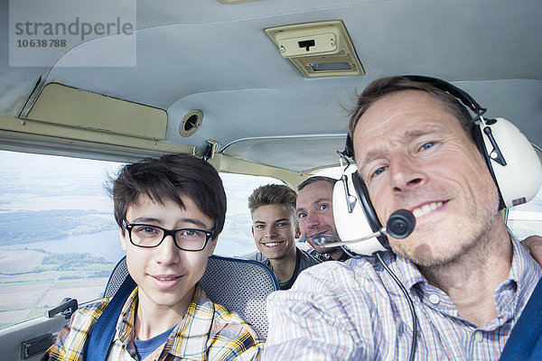 Porträt von Männern und Teenagern im Privatflugzeug