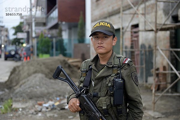 Junger Polizist  schwer bewaffnet  bewacht eine Straße  Quibdo  Departamento del Chocó  Kolumbien  Südamerika