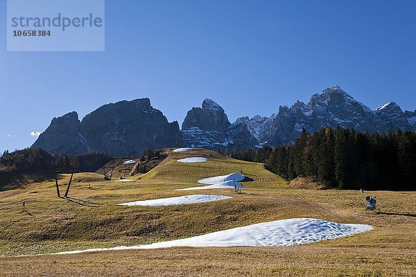 Beschneiungsanlage im Herbst  braune Wiese mit Schneehaufen  hinten Berge  Kreuzbergpass  Sextner Dolomiten  Südtirol  Italien  Europa