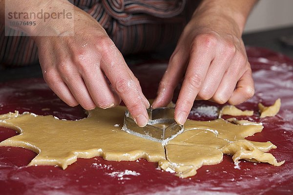 Frau sticht aus Teig Form aus zum Kekse  Plätzchen backen