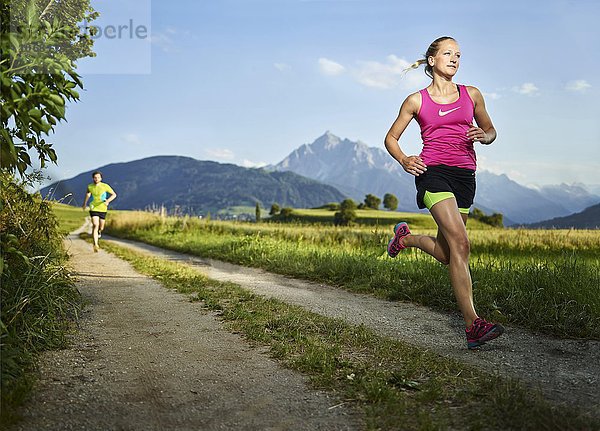 Junge Frau  20-25 Jahre  läuft auf einem Weg durch Wiesen  Rosengarten  Tirol  Österreich  Europa