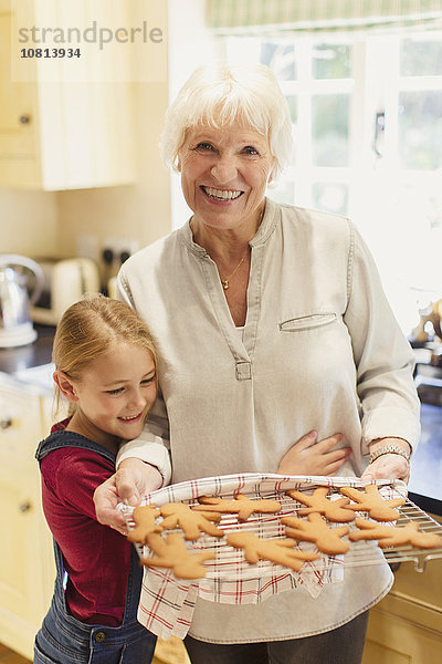 Portrait lächelnde Großmutter und Enkelin beim Lebkuchenbacken