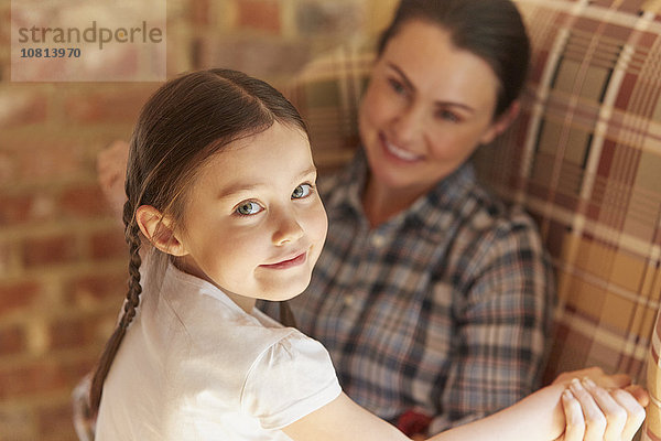 Porträt lächelndes Mädchen hält sich an den Händen der Mutter