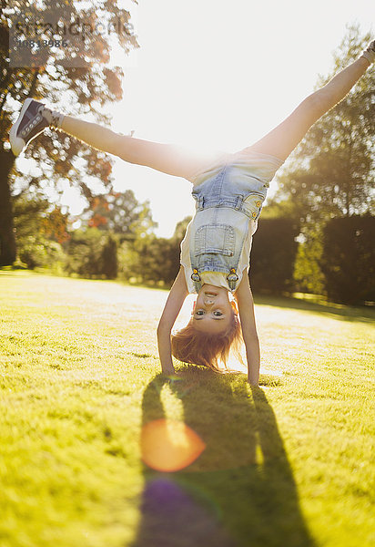 Mädchen beim Handstand im sonnigen Garten