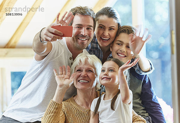 Mehrgenerationen-Familie winkt und nimmt Selfie