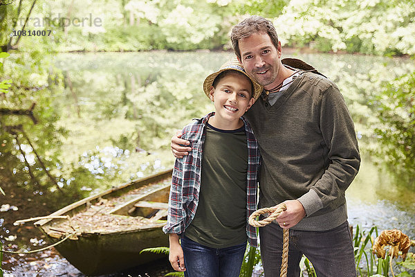 Portrait Vater und Sohn mit Boot am Teich