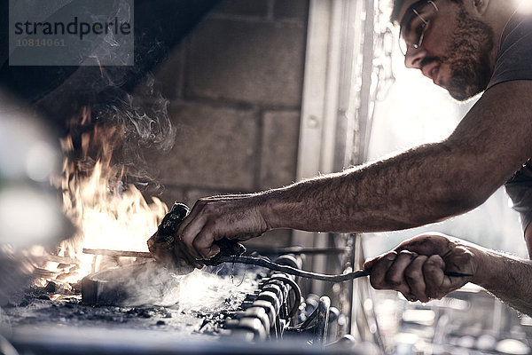 Schmiedearbeit über Feuer in der Schmiede