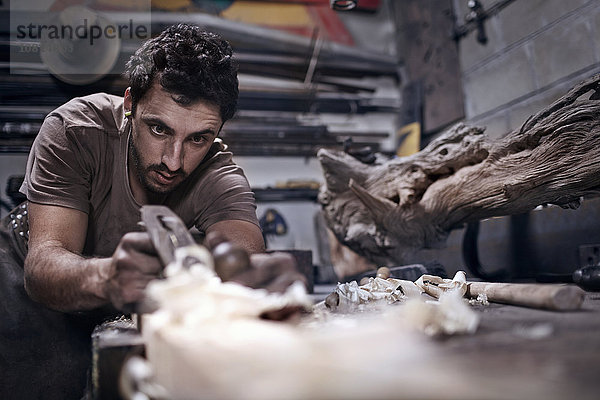 Handwerker beim Meißeln von Holz in der Werkstatt