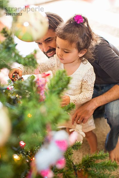 Vater und Tochter schmücken den Weihnachtsbaum