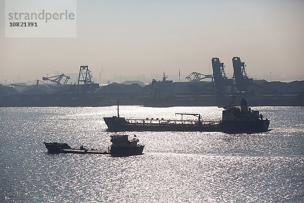 Containerschiffe  Kräne und Container im Hafen im Hintergrund
