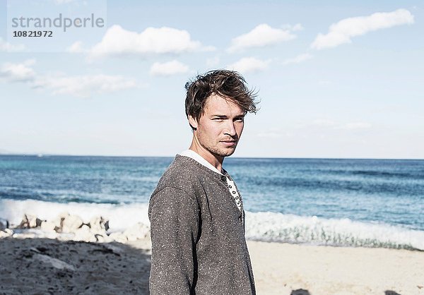 Junger Mann am Strand vor der Kamera  Costa Smeralda  Sardinien  Italien