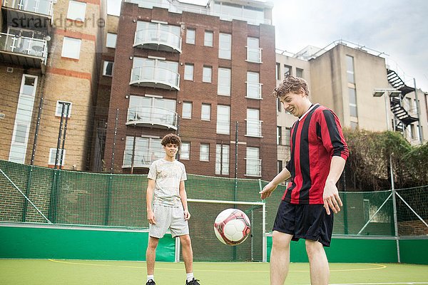 Zwei junge Männer spielen Fußball auf dem Stadtfußballplatz