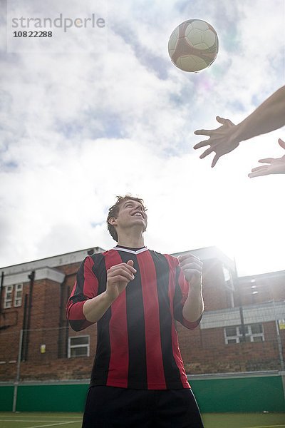 Zwei junge Männer spielen mit Fußball auf dem Stadtfußballplatz