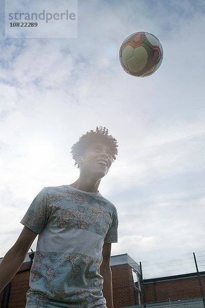 Junger Mann  der Fussballfähigkeiten trainiert