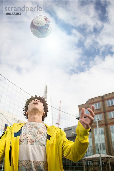 Junger Mann  der Fussballfähigkeiten trainiert