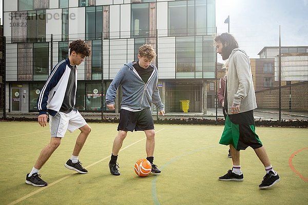 Gruppe von Erwachsenen  die auf dem Stadtfußballplatz Fußball spielen