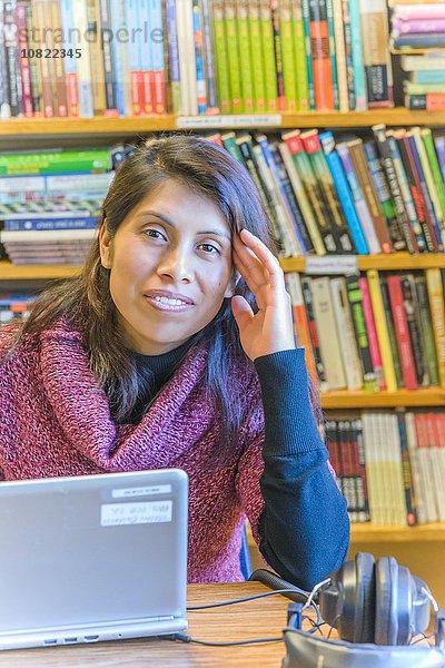 Portrait einer reifen Studentin mit Laptop in der Bibliothek