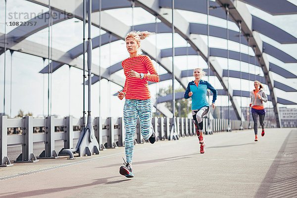 Drei Läuferinnen laufen über die Stadtbrücke