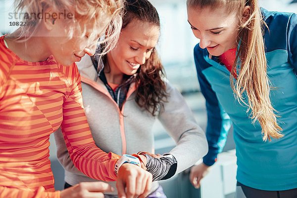 Drei Läuferinnen kontrollieren die Zeit auf Smartuhren