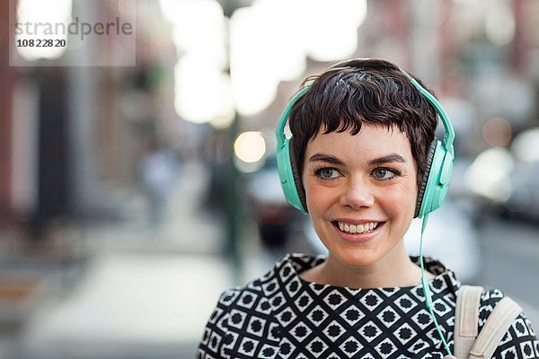 Mittlere erwachsene Frau  Retro-Kleidung  Kopfhörer tragend  Outdoor
