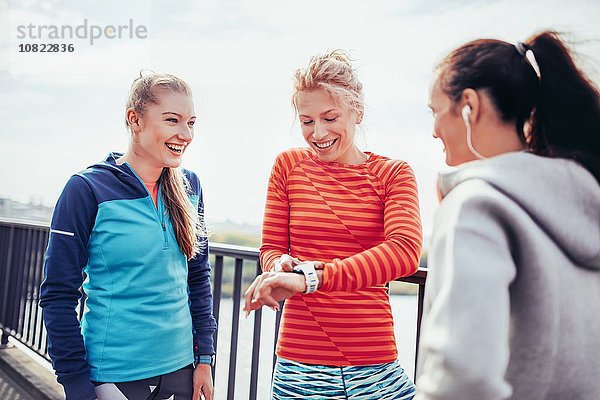 Drei Läuferinnen koordinieren die Zeit auf der Stadtbrücke