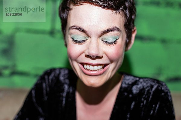 Mittlere erwachsene Frau mit grünem Lidschatten  lächelnd