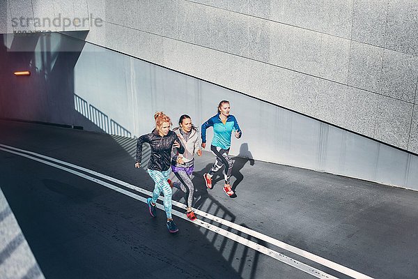 Drei Läuferinnen rasen durch die Stadtunterführung