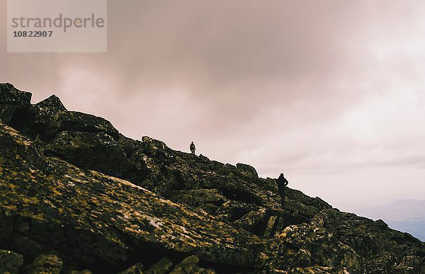 Scherenschnitt zweier Männer beim Wandern auf schroffen Felsen  Ural  Russland