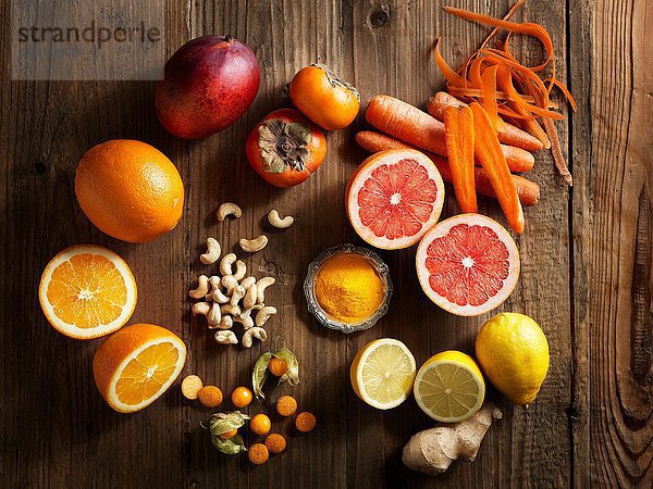 Overhead-Ansicht von orangefarbenem Obst und Gemüse auf Holzdekor-Hintergrund