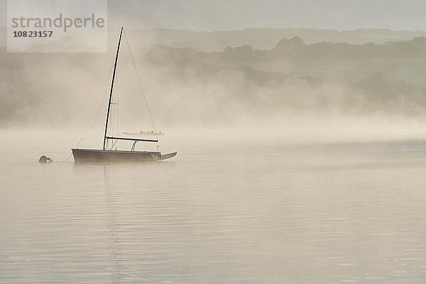 Scherenschnitt-Yacht auf dem nebligen Wimbleball-See im Morgengrauen  Exmoor  Somerset  England